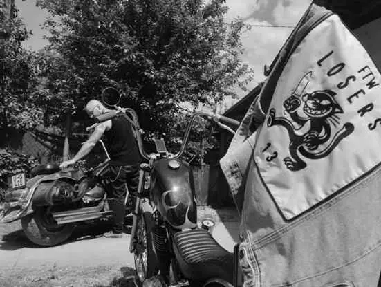 Rider with a purple chopper and a LOSERS vest in the foreground